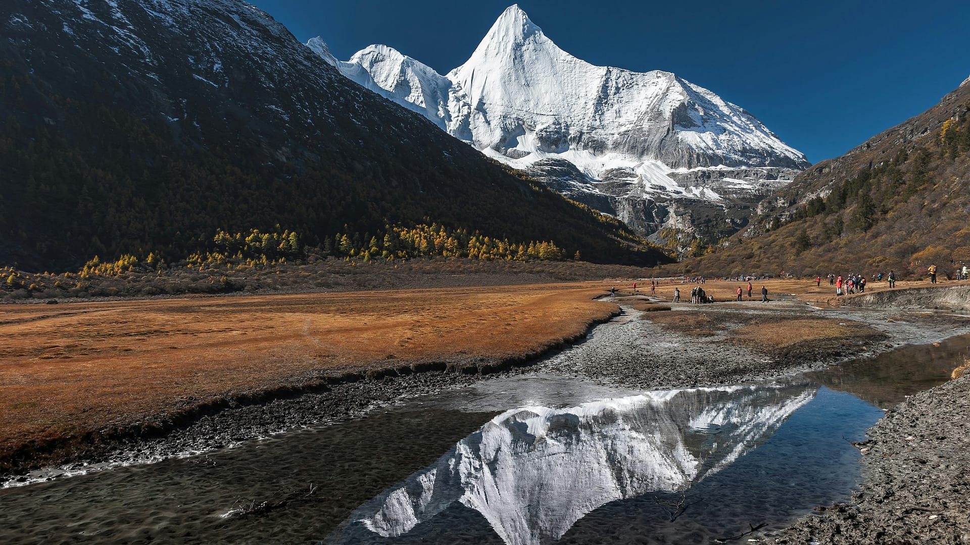 Jambeyang sacred peak with autumn meadow and stream reflection at Yading, Daocheng, Sichuan