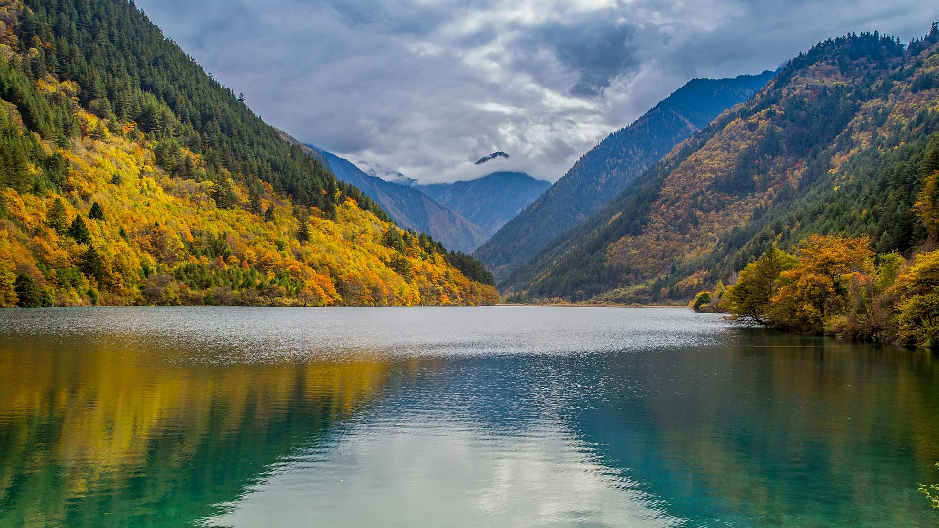 Jiuzhaigou Valley in autumn — UNESCO World Heritage with golden foliage reflected in turquoise lake, Sichuan