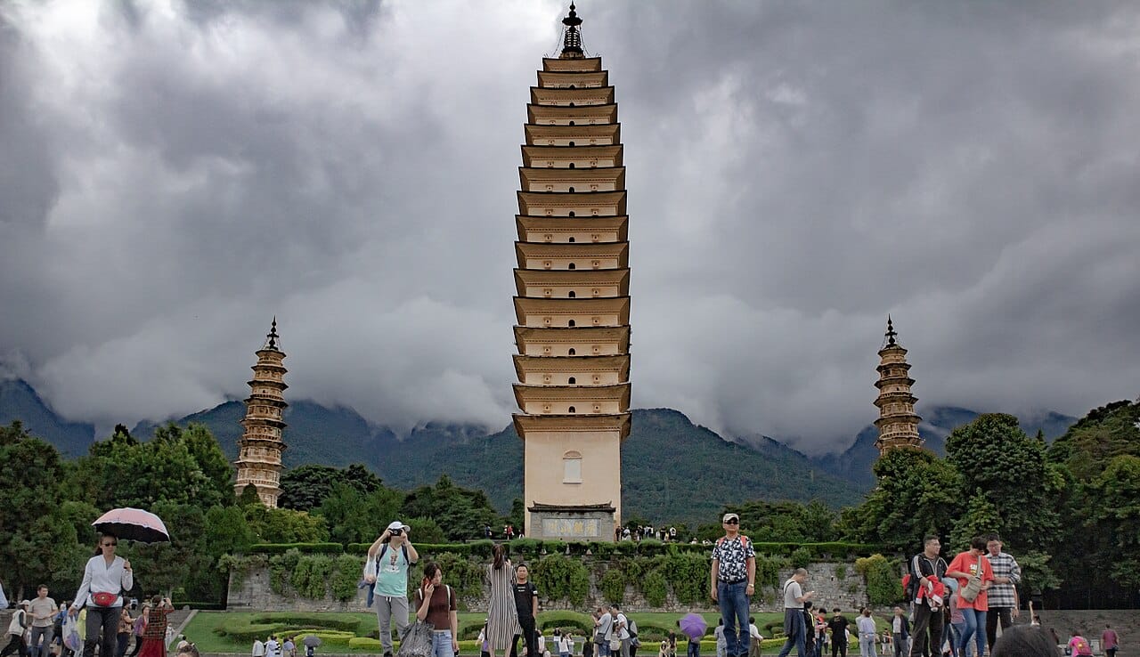 The Three Pagodas of Chongsheng Temple reflected in a lake with Cangshan mountains behind, Dali, Yunnan